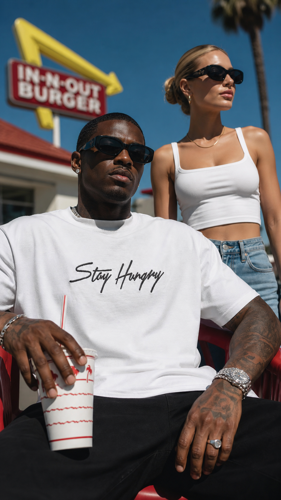 Couple in white Stay Hungry tees outside an In-N-Out Burger in California sunshine